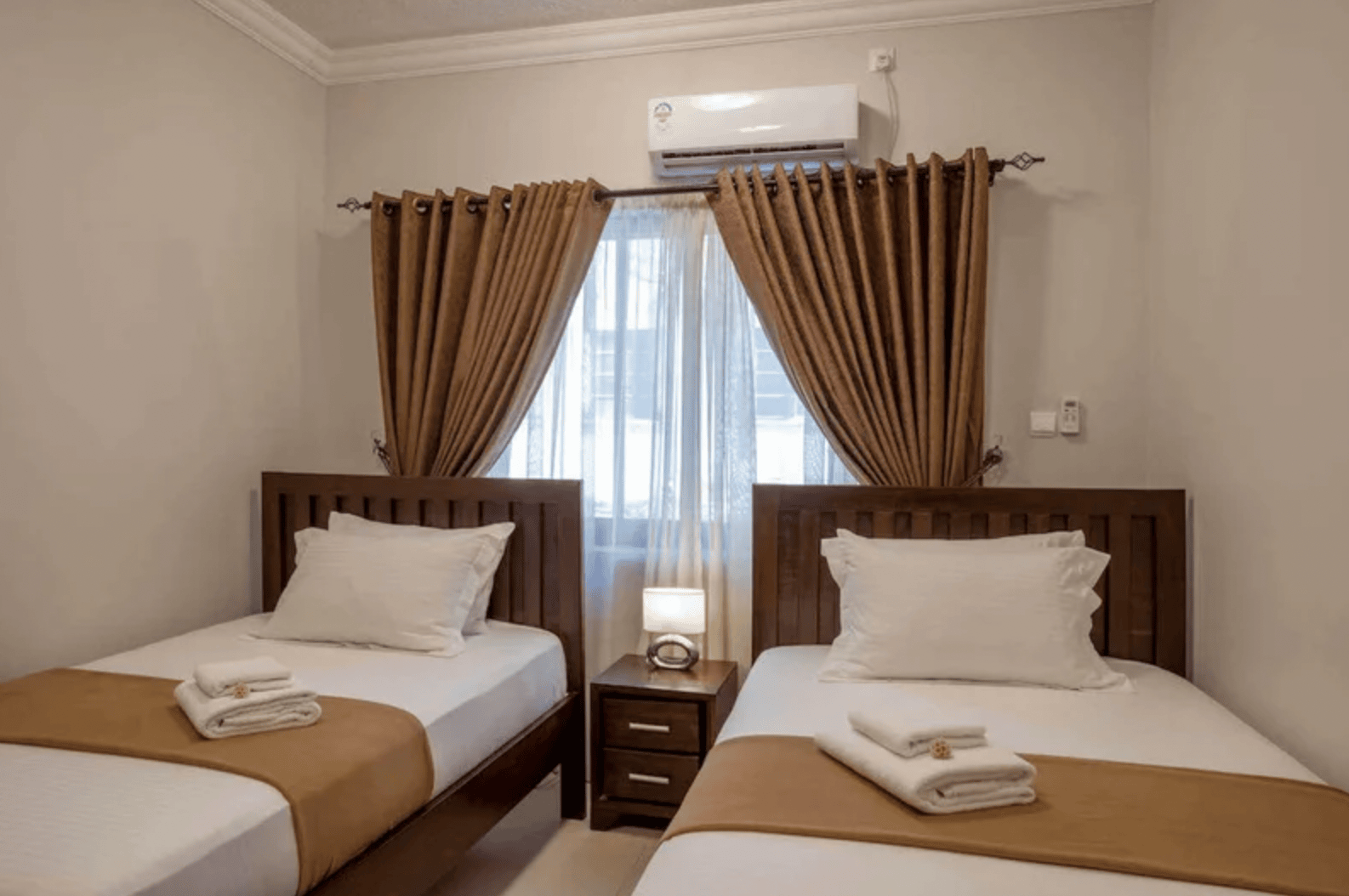 Room with two single beds at Marjaan Luxury Apartments in Mombasa, Kenya.