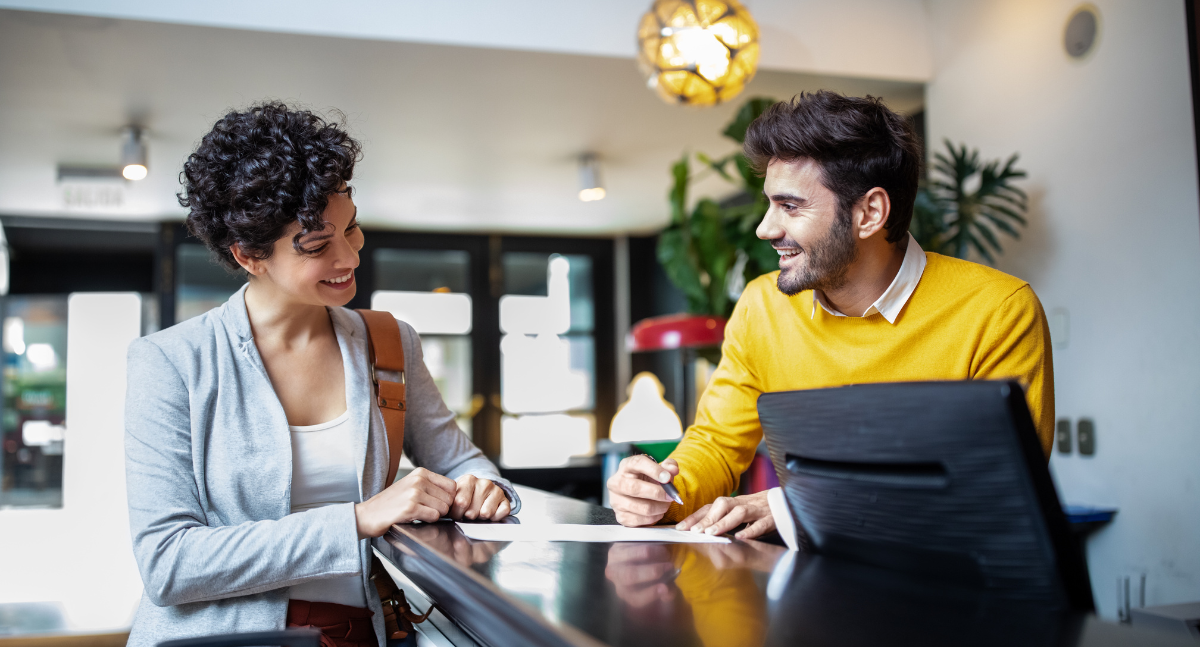 Personal masculino de recepción de hotel sonriendo al huésped